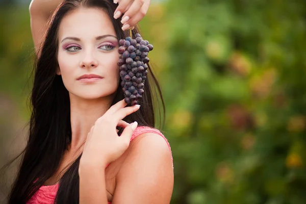 Retrato de jovem mulher bonita em uvas — Fotografia de Stock