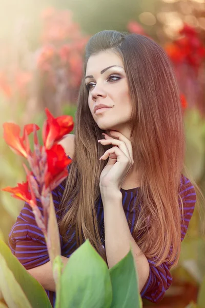 Portrait of a beautiful woman in flowers outdoors — Stock Photo, Image