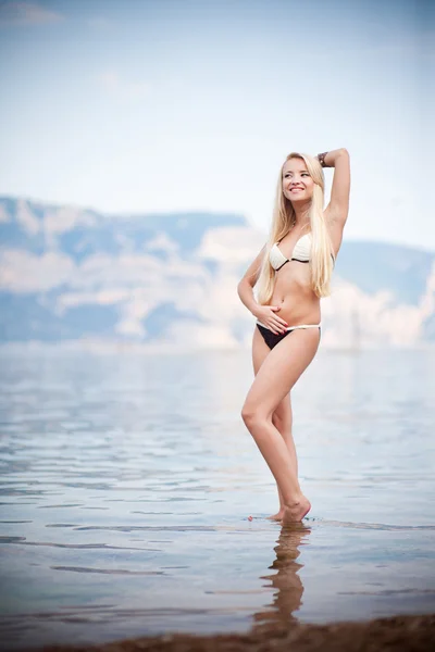 ビーチの海岸沿いに美しい若い女性 — ストック写真