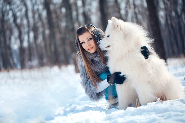 Szczęśliwa kobieta z samoyed pies w lesie zimą — Zdjęcie stockowe