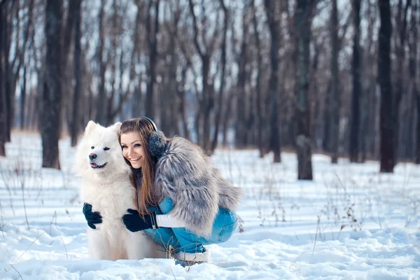 Mujer feliz con perro Samoyedo en el bosque de invierno — Foto de Stock