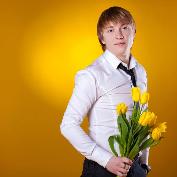 Elegante hombre sosteniendo flores — Foto de Stock