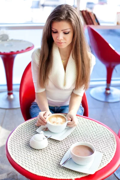 Bella giovane donna seduta nel caffè con una tazza di tè — Foto Stock