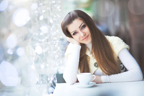 Kafede bir fincan çay içen güzel genç bir kadın. — Stok fotoğraf