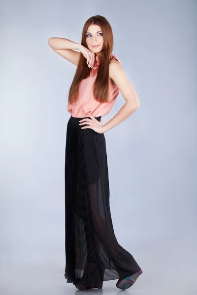 Beautiful woman in long skirt and blouse on grey — Stock Photo, Image