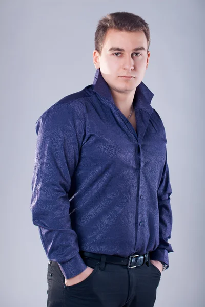 Portrét mladého pohledného muže v modré košili izolované na bílém pozadí — Stock fotografie