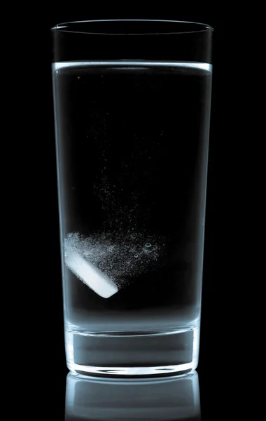 Таблетки в стакане воды изолированы на белом — стоковое фото