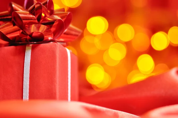 Closeup of a red gift box with blurred lights on background — Stock Photo, Image