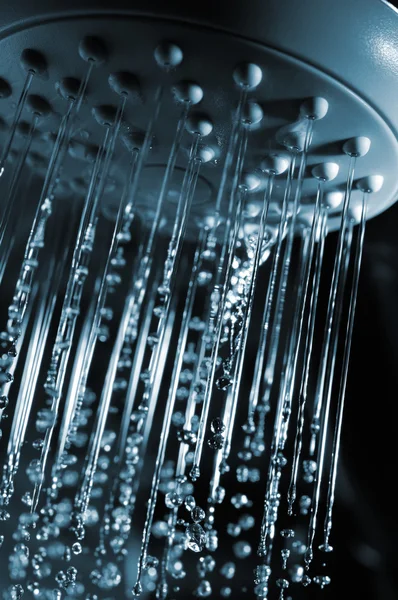 stock image Closeup view of water flowing out of shower in dark