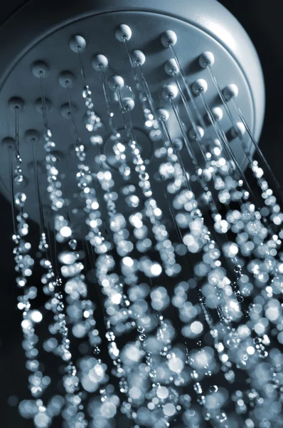 stock image Closeup view of water flowing out of shower in dark