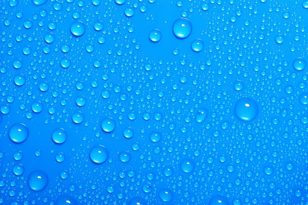 Mavi su damlaları cama düşer — Stok fotoğraf