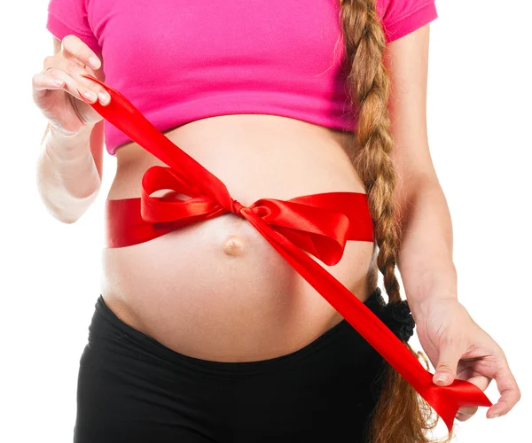 Kobieta w ciąży z jedwabną kokardą czerwony — Zdjęcie stockowe