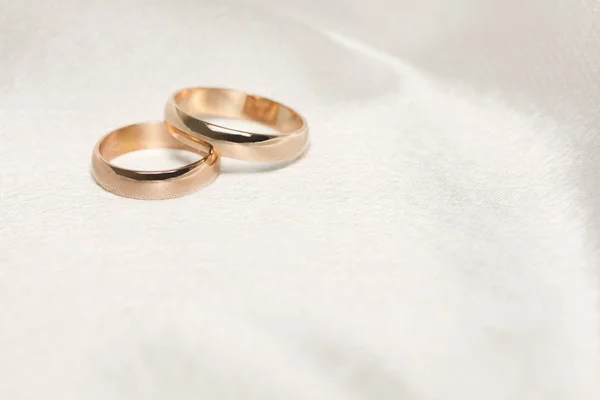 Två bröllop ringar på vitt tyg — Stockfoto