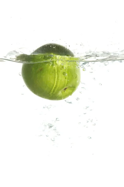 Зеленое яблоко в воде — стоковое фото