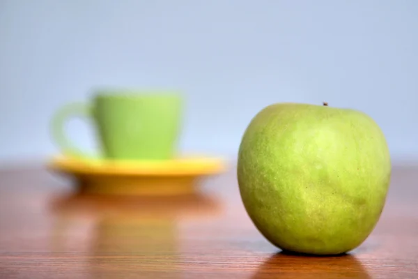 Green apple and teacup — Stock Photo, Image