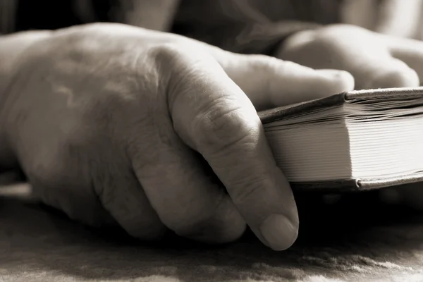 Viejas manos manteniendo una biblia — Foto de Stock