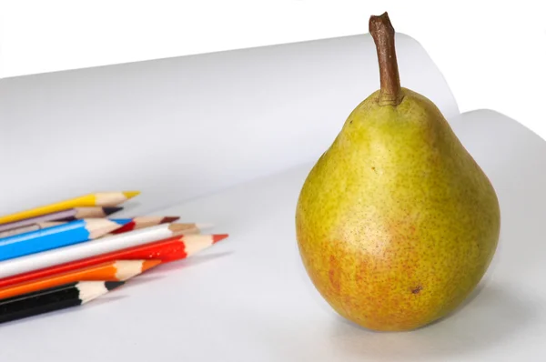 Pencils and yellow pear on the album — Stock Photo, Image