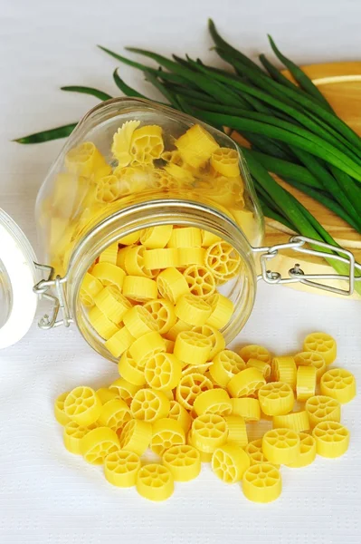 Gelbe Nudeln im Glas mit Zwiebeln — Stockfoto