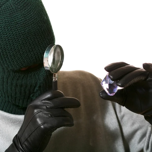 Thief with magnifier and jewel — Stock Photo, Image