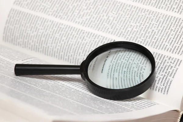 Magnifier on book — Stock Photo, Image
