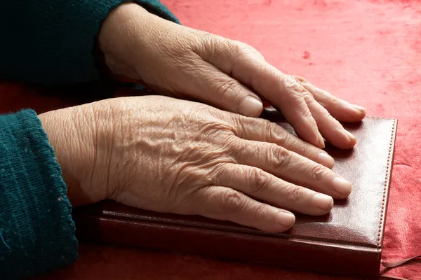 Old hands on the bible — Stock Photo, Image