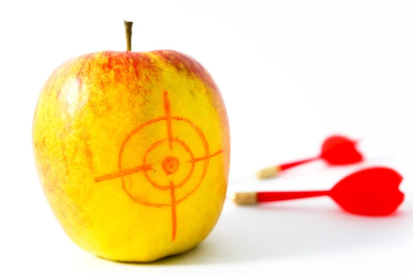 Жовте яблуко з дротиками — стокове фото