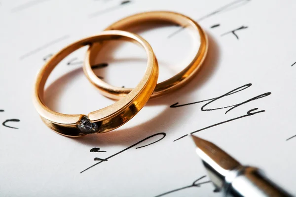 Golden rings and pen — Stock Photo, Image