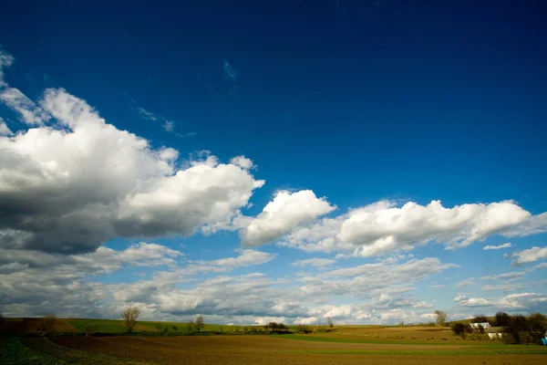 Geploegd veld en bewolkte hemel — Stockfoto
