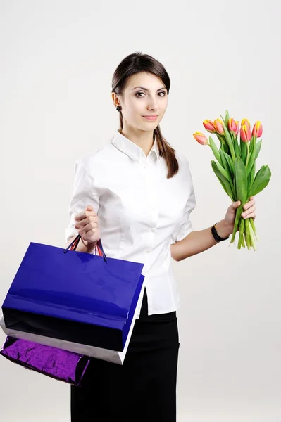 Mulher com tulipas e com sacos — Fotografia de Stock