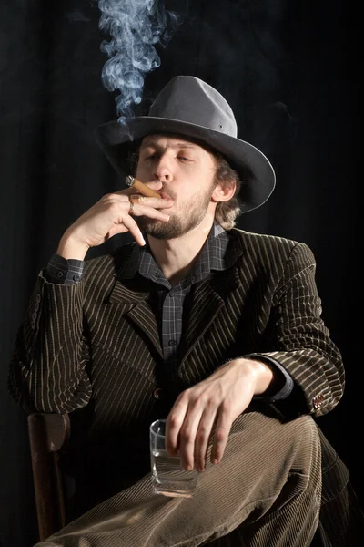 Курящий мужчина со стеклом — стоковое фото