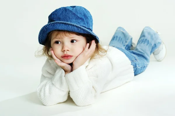 Una niña con un sombrero azul y un jersey blanco: fotografía de stock ©  velkol #9363255