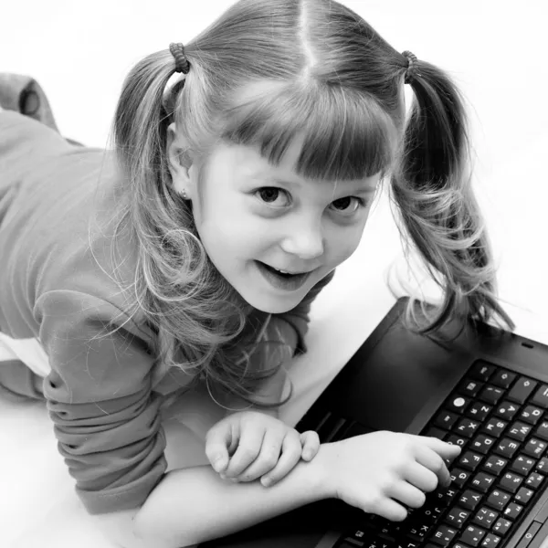 Liten flicka och bärbar dator — Stockfoto
