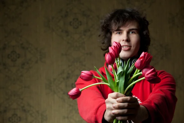 Jonge man met tulpen — Stockfoto