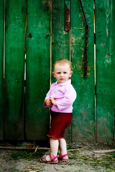 Baby in de buurt van hek — Stockfoto