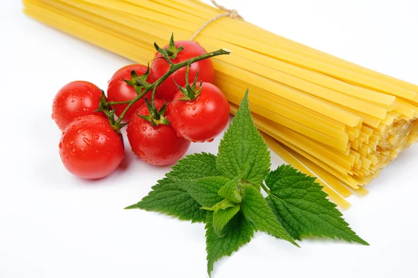 Pasta und frische rote Tomaten auf weißem Hintergrund — Stockfoto