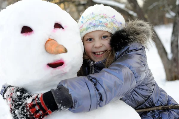 stock image Happy little girl posing with snowman