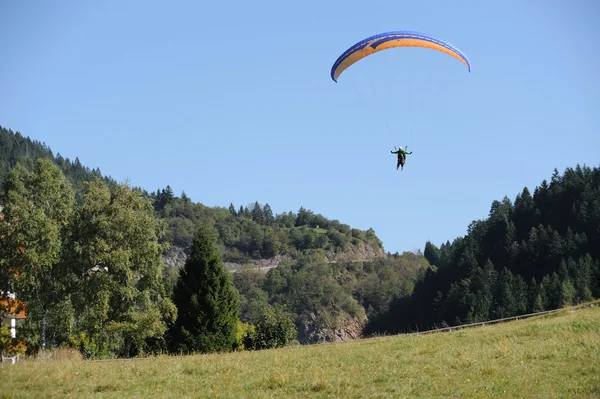 Paragliding over the mountains against clear blue sky — Stock Photo, Image