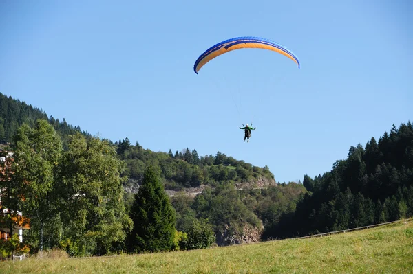 Paragliding over the mountains against clear blue sky — Stock Photo, Image