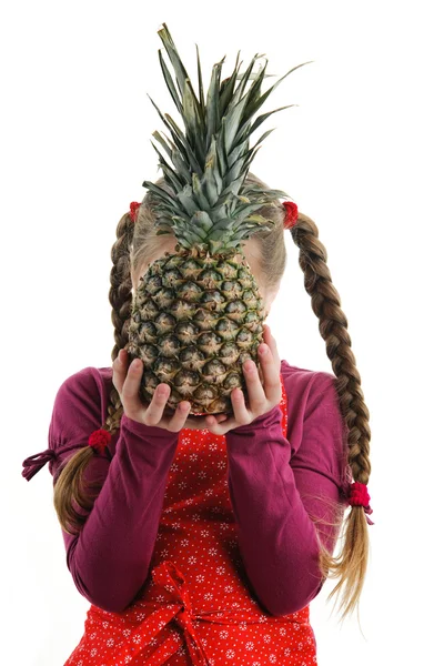 En liten flicka med en välsmakande ananas — Stockfoto