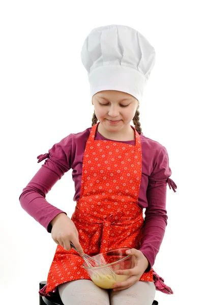 En liten flicka som rör något i en skål — Stockfoto