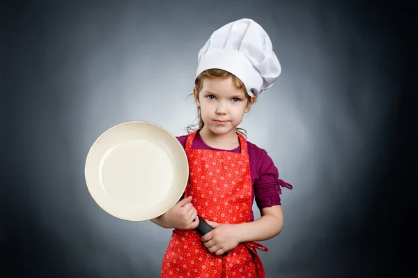 A little girl in white hat with frying pan — Stock Photo, Image