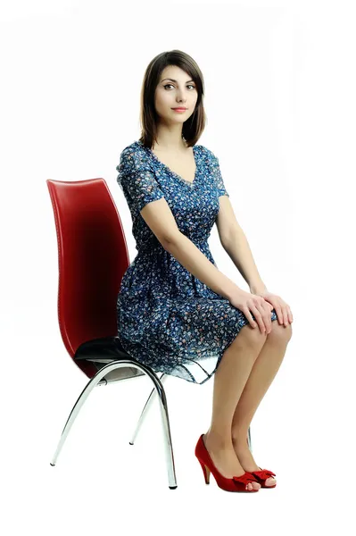 Uma jovem sentada em uma cadeira — Fotografia de Stock