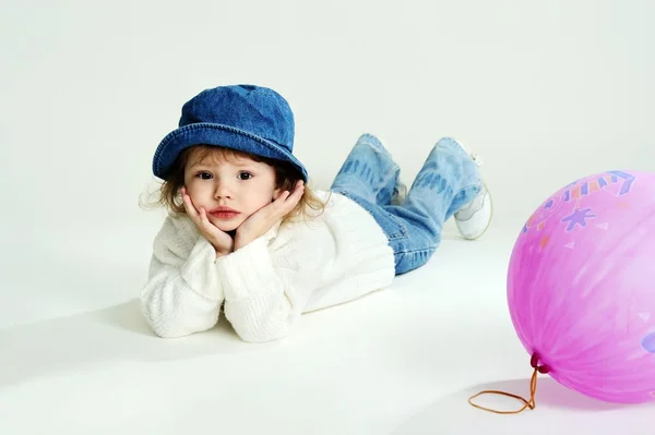 O fetiță într-o pălărie și săritor alb cu balon — Fotografie, imagine de stoc