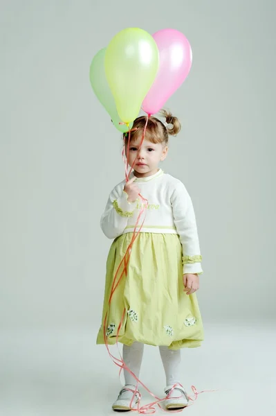 Un retrato de una niña bonita con tres globos — Foto de Stock