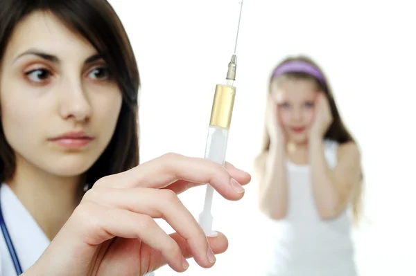 Doctor getting ready to make an injection to a young girl — Stock Photo, Image