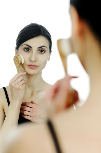 A young woman cleaning her face with a brush — Stock Photo, Image