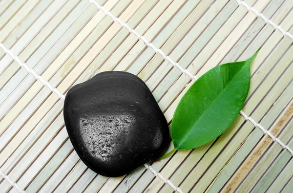Spa ve yeşil yaprak için siyah taş — Stok fotoğraf