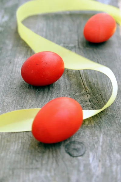 Tři červené vejce a žlutý pruh — Stock fotografie