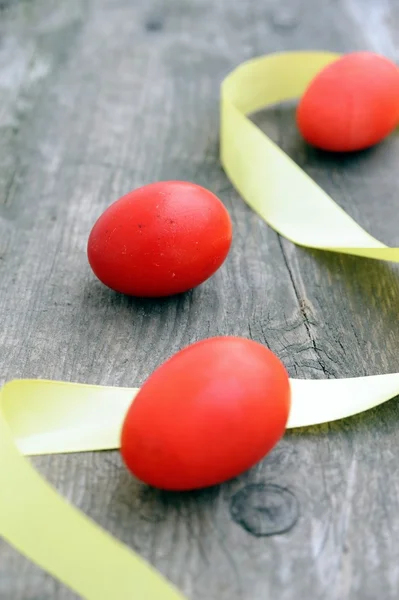Три красных яйца и желтая полоска — стоковое фото