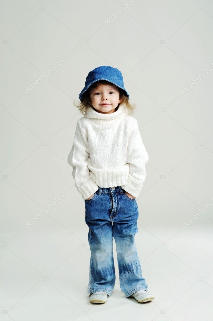 A little girl in a blue hat and white jumper